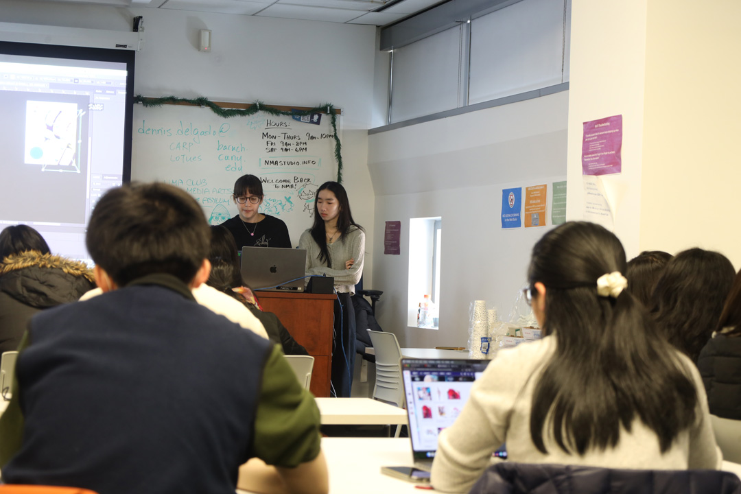 A backview of students in the NMA Studio listening to two docents give a workshop.
