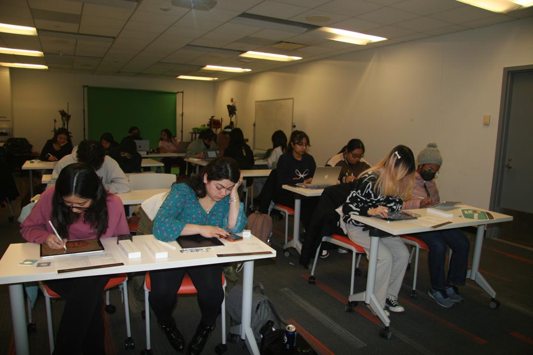 New Media Arts studio filled with desks and students using laptops and tablets.