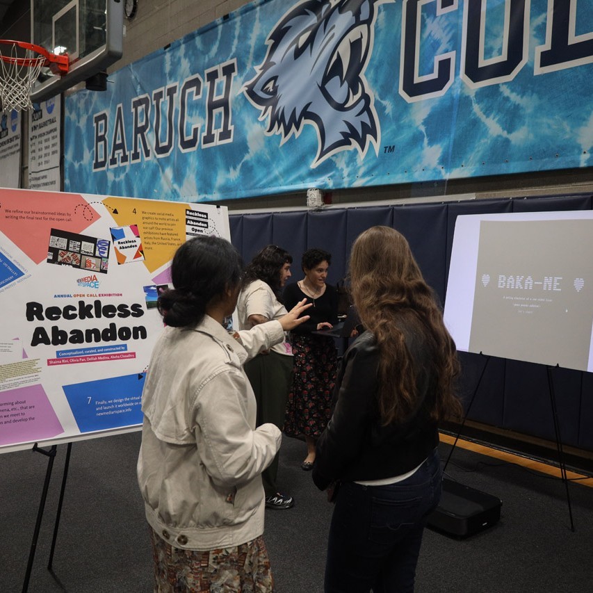 People stand around a poster on an easel.